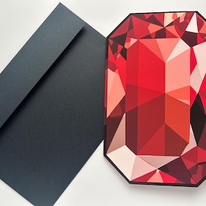 以下が含まれることがあります： 黒い縁取りのある大きな赤い宝石の幾何学的なイラストと、濃い灰色の封筒。 宝石のデザインは、さまざまな赤とピンクの色合いを特徴とし、ファセットの外観を作り出しています。 封筒はシンプルな長方形の形をしています。