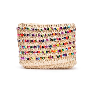 Può includere: Una pochette in paglia intrecciata con file orizzontali di perline colorate. Le perline sono nelle tonalità di rosso, arancione, giallo, verde, blu e viola. La pochette ha una forma rettangolare e un colore neutro.