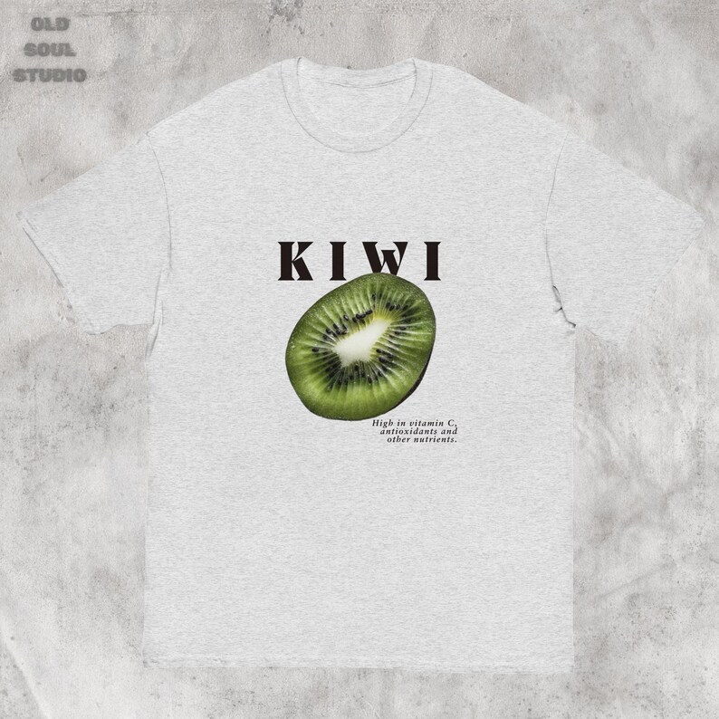 Gray Y2K aesthetic unisex t-shirt featuring a bold KIWI text, a vibrant kiwi graphic, and small retro-inspired text below. A tropical, playful vibe perfect for casual, streetwear looks