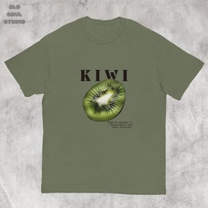 Green Y2K aesthetic unisex t-shirt featuring a bold KIWI text, a vibrant kiwi graphic, and small retro-inspired text below. A tropical, playful vibe perfect for casual, streetwear looks