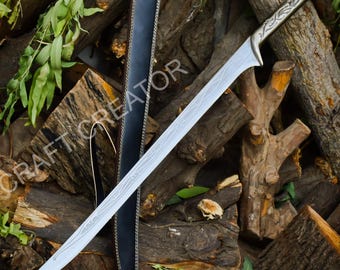 May include: A silver-colored sword with an ornate handle and a long, curved blade. The blade features etched designs. A black leather sheath is visible. The sword rests on a pile of wood logs. The text "CRAFT CREATOR" is visible.
