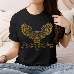 May include: Black t-shirt featuring a gold owl graphic and the text "You Have No Power Over Me".