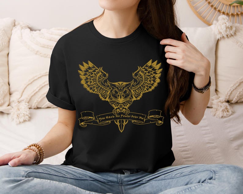 May include: Black t-shirt featuring a gold owl graphic and the text "You Have No Power Over Me".