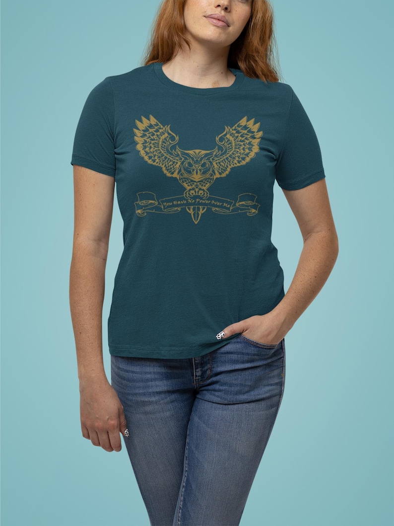 May include: Teal blue t-shirt featuring a gold owl graphic and the text "You Have To Trust Your Own Magic".