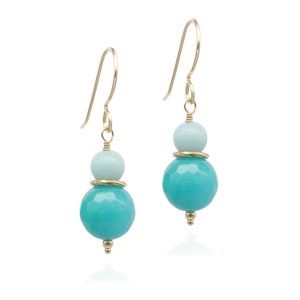 May include: Gold earrings with two turquoise and light blue gemstone beads.