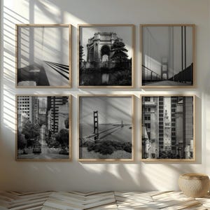 May include: A set of six black and white framed photographs of various San Francisco landmarks, including the Golden Gate Bridge, the Palace of Fine Arts, and the city skyline.