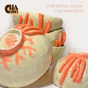 Puede incluir: Cuencos de cer&aacute;mica hechos a mano apilados, con una base color crema y detalles texturizados color coral. Los cuencos tienen una forma org&aacute;nica &uacute;nica y est&aacute;n decorados con dise&ntilde;os en relieve en forma de ramas. Incluye el texto "Small batches, big love. Truly handcrafted."