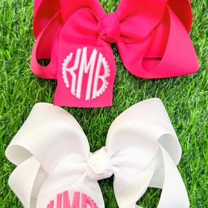 white and hot pink grosgrain ribbon hair bows, made with scallop monograms on the tails edge