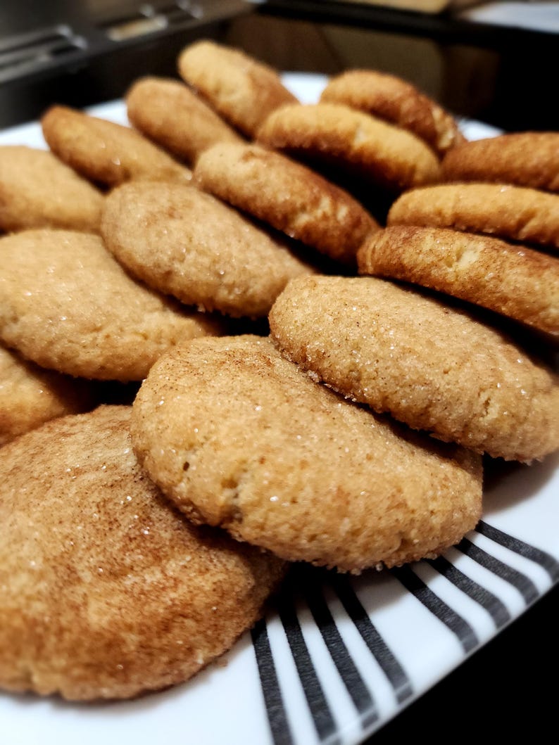 May include: A plate of freshly baked cinnamon sugar cookies. The cookies are golden brown and have a slightly crispy texture.