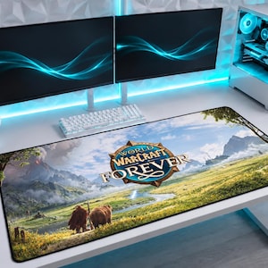 Op de afbeelding: Een rechthoekige bureaumat met een World of Warcraft Forever grafische print. Het ontwerp toont een levendig landschap met groene velden, een kronkelende rivier, bergen en twee bruine beren op de voorgrond onder een helderblauwe lucht.