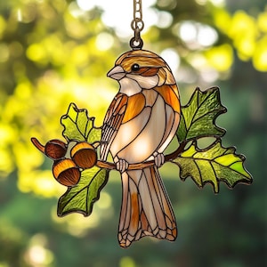 Puede incluir: Atrapasoles de pájaro de vidriera con un gorrión detallado posado en una rama con hojas verdes y bellotas. El pájaro tiene colores marrón, naranja y blanco. Incluye una cadena para colgar. Un artículo decorativo con temática de la naturaleza.