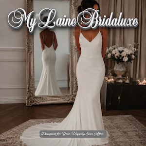 Puede incluir: Un vestido de novia blanco hasta el suelo con tirantes finos, escote en V y una silueta ajustada que se ensancha en el dobladillo. El texto My Laine Bridaluxe y Designed for Your Happily Ever After son visibles en la imagen.