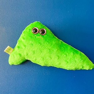 May include: A bright green plush toy with large, purple, sparkly eyes. The toy has a textured surface and a tag that reads "jankink.etsy.com". The toy is set against a blue background.