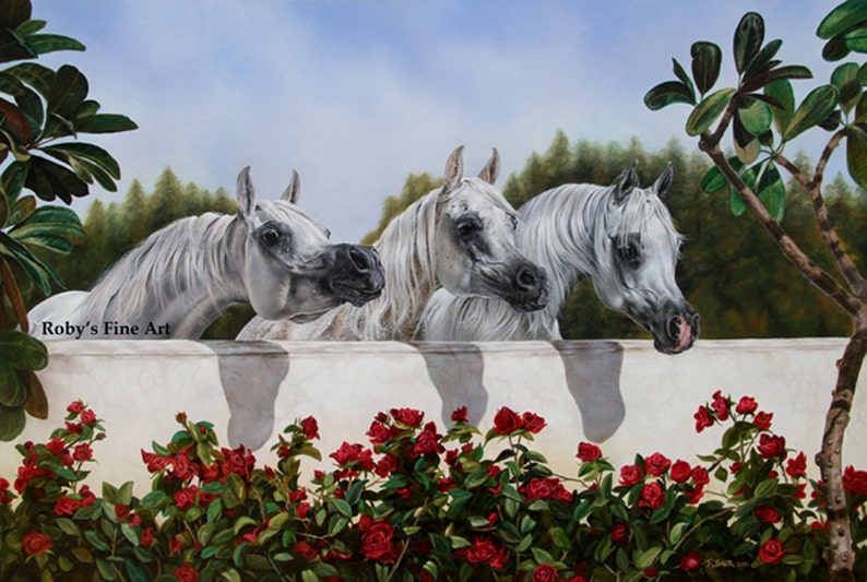 May include: An oil painting depicts three white horses with flowing manes, peering over a white wall. Lush red roses bloom below, with green foliage and a backdrop of trees and sky. The artwork is signed "Roby's Fine Art".