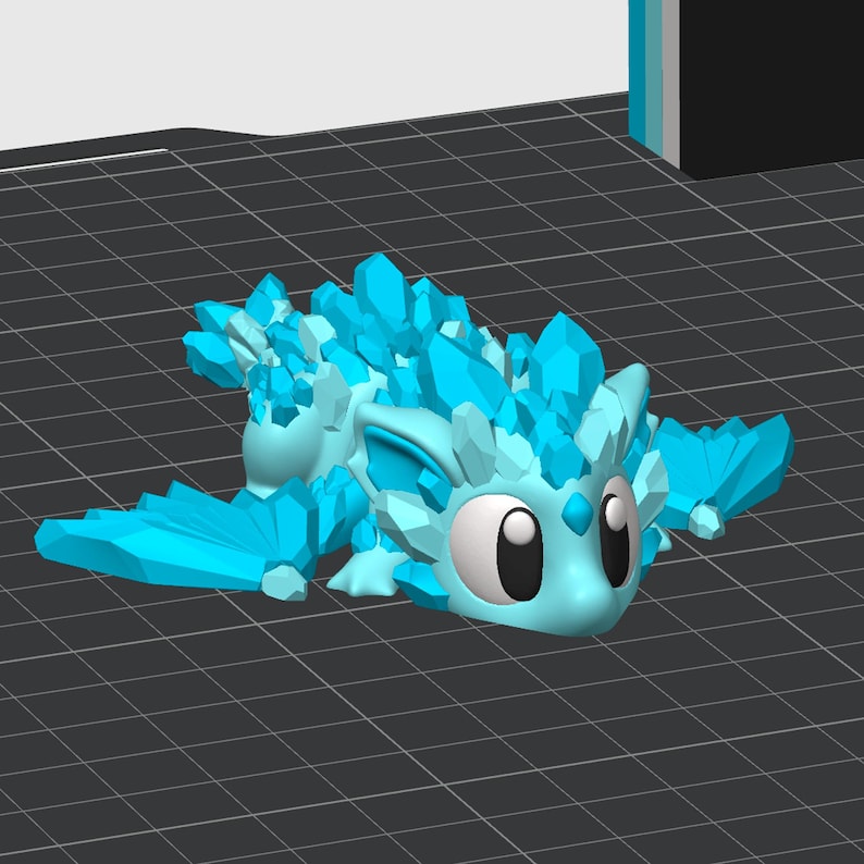 May include: A blue crystal dragon figurine with large eyes and wings. The dragon is covered in small, sharp crystals.
