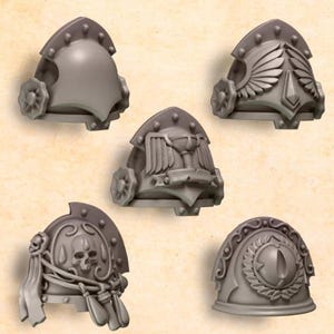 May include: Five gray shoulder pads with various designs. One has a simple rounded shape, while others feature wings, a chalice, a skull, and an eye. Each pad has a decorative wheel on the side and a curved top with small studs.