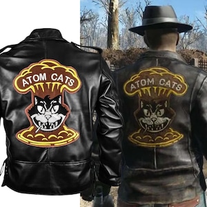 May include: Black leather jacket with a large embroidered patch on the back. The patch features a cartoon cat with a cigarette in its mouth, a mushroom cloud, and the text "ATOM CATS".