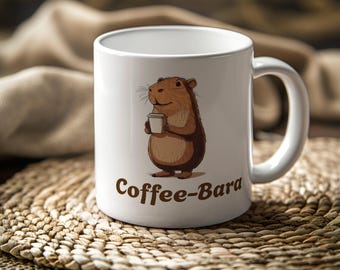 Op de afbeelding: Een witte keramische mok met een bruine cartoon capybara die een kopje koffie vasthoudt. Op de mok staat de tekst "Coffee-Bara" gedrukt.