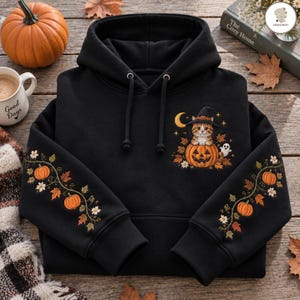 Peut inclure: Un sweat-shirt à capuche noir avec un motif sur la poitrine représentant un chat portant un chapeau de sorcière assis dans une citrouille d'Halloween, un croissant de lune et un fantôme. Les manches présentent des motifs de citrouilles orange.