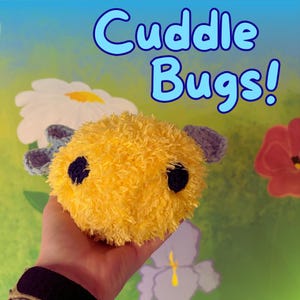 May include: A plush, yellow toy bug with black eyes and purple accents. The toy is held in a hand against a colorful background with the text "Cuddle Bugs!" in blue. The toy has a fuzzy texture.