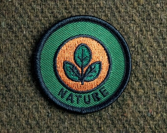 May include: A green and orange embroidered patch with the word "NATURE" and a stylized green leaf design.