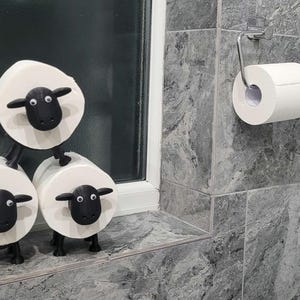 sheep toilet roll holders designed to be fitted into inner toilet roll or loo rolls as a fun sheep holder. googley eyes and black colour. 4 legs with a base and head. no mouth variation.