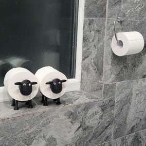 sheep toilet roll holders designed to be fitted into inner toilet roll or loo rolls as a fun sheep holder. googley eyes and black colour. 4 legs with a base and head. no mouth variation.
