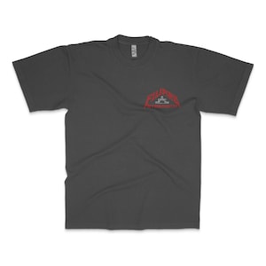 May include: Dark gray t-shirt with a red graphic on the upper left chest. The graphic features the word "FILIPINO" above "STRENGTH" in a stylized font. The shirt has short sleeves and a crew neck.