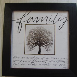 May include: A framed print with a black frame and a white background. The print features a stylized tree with the text "family" above the tree and the text "like branches of a tree, we grow in different directions but our roots remain as one" below the tree.