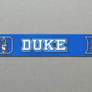 May include: A blue ribbon with the word "DUKE" in white block letters repeated three times. The Duke University logo, a stylized image of a Blue Devil, is between the words.