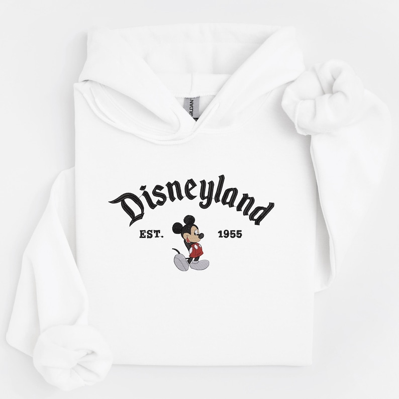 A white hoodie with the text "Disneyland EST. 1955" and a Mickey Mouse graphic printed on it.