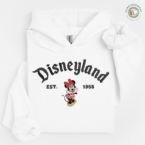 A white hoodie with the text "Disneyland EST. 1955" and a Minnie Mouse graphic printed on it.