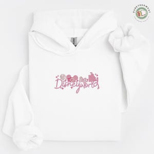 A white hoodie with a pink logo that says "Disneyworld" on it.