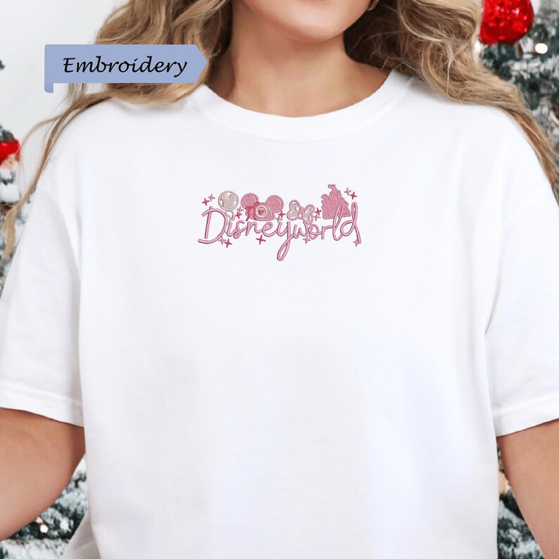 A person wearing a white t-shirt with the text "Disneyworld" embroidered on it.