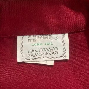 Puede incluir: Una camisa roja de cola larga con una etiqueta blanca que dice "H-Bar-C Long Tail California Ranchwear".