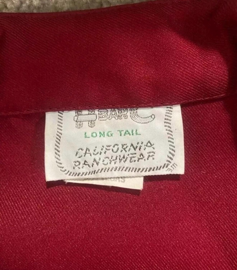 Puede incluir: Una camisa roja de cola larga con una etiqueta blanca que dice "H-Bar-C Long Tail California Ranchwear".