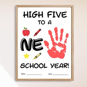 May include: Framed print with the text "HIGH FIVE TO A NEW SCHOOL YEAR!" featuring a red handprint, apple, crayons, and star. Includes spaces for a name and date. The frame is a light brown color.