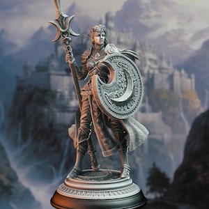 May include: A detailed, silver-colored figurine of a female warrior with pointed ears, holding a spear and a crescent moon-shaped shield. The figurine is standing on a circular base with intricate details.