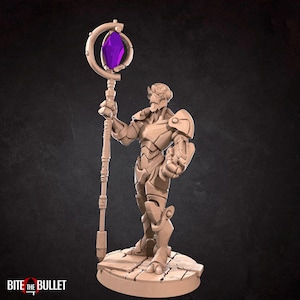May include: A beige figurine of a humanoid figure in armor, holding a staff with a purple crystal. The figure stands on a stone-like base. The staff has a crescent-shaped top. The text "BITE the BULLET" is at the bottom.