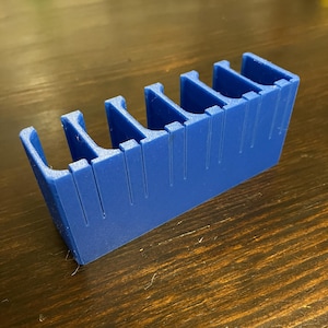 Puede incluir: Un organizador de pl&aacute;stico azul con seis compartimentos. El organizador est&aacute; dise&ntilde;ado para guardar objetos peque&ntilde;os, como piezas de juego o materiales de manualidades.