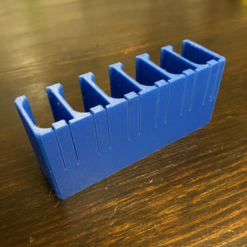 Puede incluir: Un organizador de pl&aacute;stico azul con seis compartimentos. El organizador est&aacute; dise&ntilde;ado para guardar objetos peque&ntilde;os, como piezas de juego o materiales de manualidades.