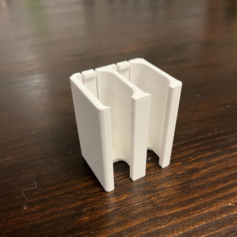 Puede incluir: Organizador de pl&aacute;stico blanco impreso en 3D con tres ranuras para guardar objetos peque&ntilde;os.