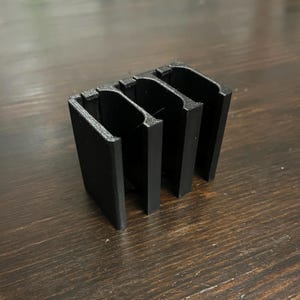 Puede incluir: Organizador de pl&aacute;stico negro impreso en 3D con tres ranuras.