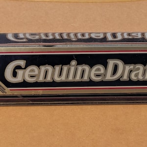 May include: A rectangular Pabst Genuine Draft tap handle with a black, gold, and silver design. The handle features the words "Genuine Draft" in white lettering, with the Pabst logo and brand name prominently displayed.