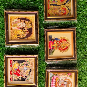 May include: Five framed religious art pieces featuring colorful depictions of deities. Each artwork is encased in a brown wooden frame with a gold-colored inner border. The images showcase intricate details and vibrant colors, set against a backdrop of green grass.