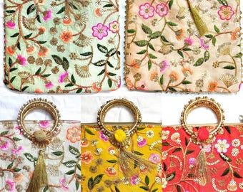 Puede incluir: Bolsos bordados en varios colores: verde, melocotón, blanco, amarillo y rojo. Cada bolso presenta patrones florales, asas doradas y borlas decorativas. Los bolsos rectangulares tienen cierre de cremallera.
