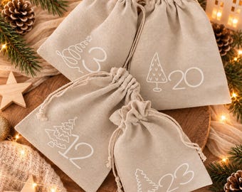 Könnte beinhalten: Vier beige Stoffbeutel mit Kordelzug, verziert mit weißen Strichzeichnungen von Weihnachtsbäumen und den Zahlen 3, 12, 20 und 23. Jeder Beutel hat einen gerafften Verschluss mit passenden beigen Kordeln für den Adventskalender.