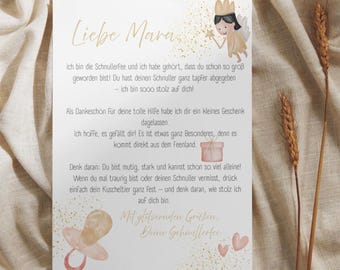 May include: A greeting card with text in German, featuring a fairy illustration and a pacifier graphic. The card is on a beige fabric background, with wheat stalks on the right side.