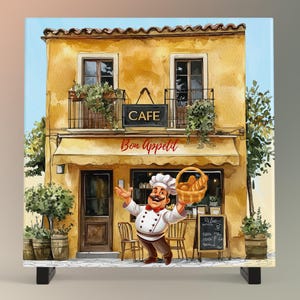 May include: A cartoon chef stands in front of a yellow building with a cafe sign that says "Cafe" and "Bon Appetit". The chef is holding a basket of bread and smiling. The building has a brown awning and two windows. There are green bushes and trees in front of the building.