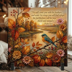 May include: A square decorative tile featuring a blue and orange bird perched on a branch amidst autumn foliage and flowers. The text reads: "He will cover you with his feathers, and under his wings you will find refuge; his faithfulness will be your shield and rampart." Psalm 91:4.